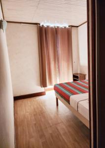 a bedroom with a bed and a window with curtains at Chambre chez Marie et Didier 1 minute à pied du sanctuaire de Lourdes in Lourdes +26 photos