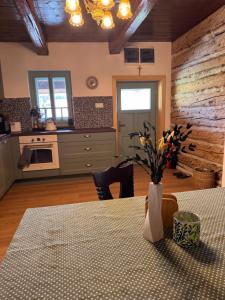 a kitchen with a table with a vase of flowers on it at Drevenica Kráľova in Šumiac +22 photos