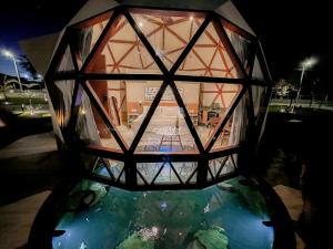 a glass lantern on top of a pool of water at Ville do Lago in Gravatá