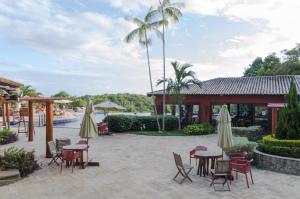 a patio at a resort with tables and chairs at Villas do Pratagy Bambu 2 in Maceió