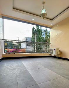 a large living room with a large window and a balcony at La case Dytobi Mermoz in Dakar