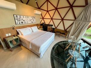 a bedroom with a bed and a glass table at Ville do Lago in Gravatá