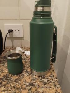 a green water bottle sitting on top of a counter at Departamento Abu Dolly in La Plata