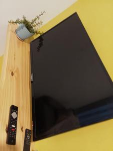 a television sitting on a table with a remote control at Departamento Abu Dolly in La Plata +5 photos