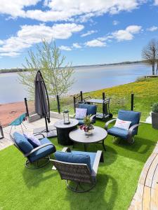 a patio with chairs and tables and a view of the water at luxury Beachfront Home With Private Beach Access in Charlottetown