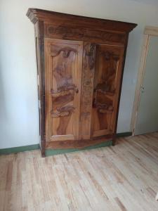 a wooden cabinet in the corner of a room at OAK Familly in Saint-Racho