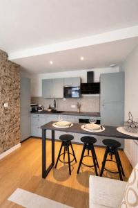 a kitchen with a table and four stools at Appartement neuf & élégant- Centre Lorient in Lorient