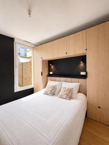 a bedroom with a large white bed and a window at Appartement neuf & élégant- Centre Lorient in Lorient