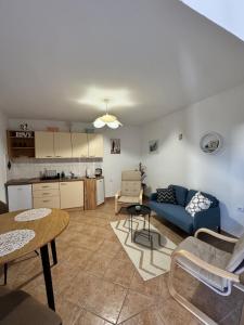 a living room with a blue couch and a table at Apartman Velina in Pakoštane
