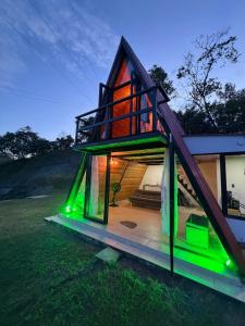 a small house with green lights on it at La Nebulosa Glamping in Vergara