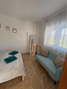 a living room with a couch and a mirror at Apartman Velina in Pakoštane