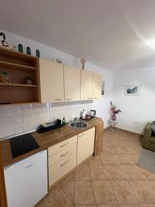a kitchen with white cabinets and a sink at Apartman Velina in Pakoštane