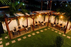 an outdoor patio with chairs and tables at night at Ahomé Guest house & Lounge in Lomé