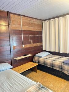 a room with two beds and a wooden wall at Chalé Mar Aberto in Atins +45 photos