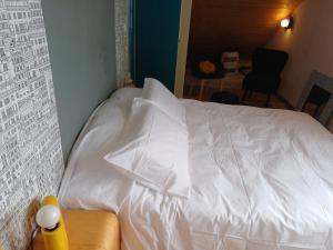 a white bed with a pillow on top of it at Soleil Bleu in Saint-Racho +4 photos