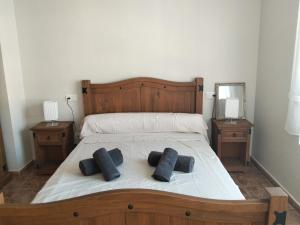 a bedroom with a bed with two black pillows on it at Casa de Cope in Calabardina