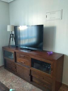 a flat screen tv sitting on top of a wooden entertainment center at Casa de Cope in Calabardina