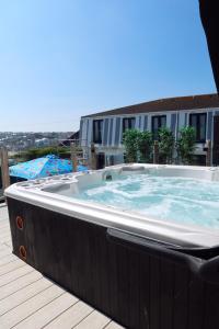 a large hot tub sitting on top of a deck at Porth Beach Hotel in Newquay