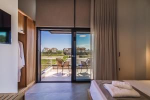 a bedroom with a bed and a view of a patio at Trithiron Luxury Villas in Nea Moudania