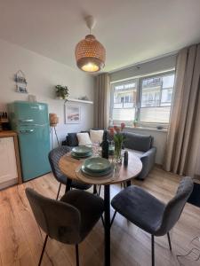 a kitchen and living room with a table and chairs at Apartamenty Modrzewiowa Enklawa in Debina