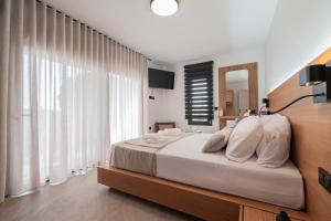 a bedroom with a bed and a large window at Trithiron Luxury Villas in Nea Moudania +88 photos