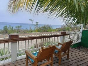 a deck with two chairs and a view of the ocean at Blue Lizard House in San Andrés