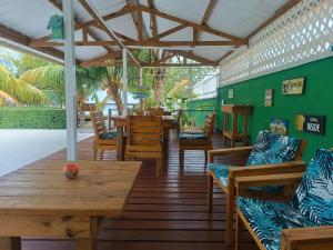 a restaurant with wooden tables and chairs and a green wall at Blue Lizard House in San Andrés +33 photos