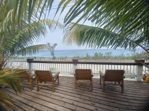 two chairs and a table on a deck with the ocean at Blue Lizard House in San Andrés