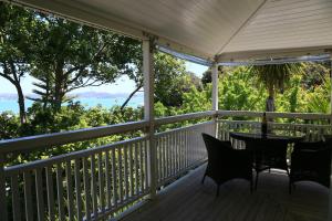 porche con mesa, sillas y vistas al océano en Villa Russell, en Russell