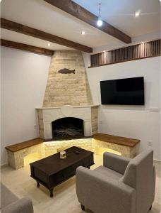 a living room with a fireplace and a flat screen tv at Skadar Lake Hideaway in Karuč