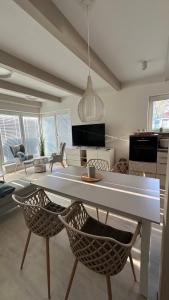 a living room with a large white table and chairs at Ferienhaus Sandbrise in Zingst