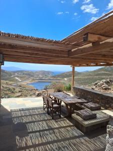 a wooden deck with a picnic table and a bench at ACHERONAS Residences in Serifos Chora