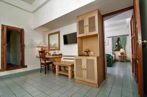 a room with a table and a desk and a room at Sativa Sanur Cottages in Sanur