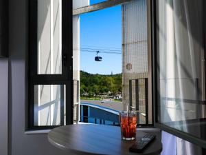 a drink sitting on a table in front of a window at Mercure Toulouse Sud in Toulouse
