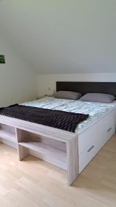a white bed with a wooden frame in a room at Apartment MASCH in Arriach