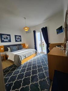 a bedroom with a large bed and a window at Farol Guesthouse in Angra do Heroísmo
