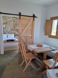 a dining room with a table and a bed at ACHERONAS Residences in Serifos Chora