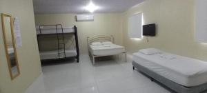 a room with two beds and a bunk bed at Habitación en Casa Las Palmitas in Penonomé