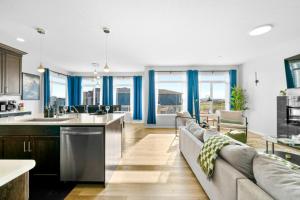a living room with a couch and a kitchen with blue curtains at Spacious 5BR, Hot Tub and Pool Table - Sleeps 16 in YYC