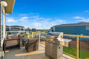 a outdoor patio with a grill and wicker furniture at Spacious 5BR, Hot Tub and Pool Table - Sleeps 16 in YYC
