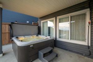 a large bath tub sitting next to a window at Spacious 5BR, Hot Tub and Pool Table - Sleeps 16 in YYC +75 photos