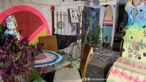 a room with a table and a statue in it at Hostel do Rasta in Ubatuba