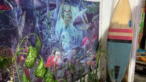 two surfboards leaned up against a wall with a painting at Hostel do Rasta in Ubatuba