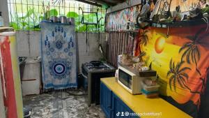 a kitchen with a stove and a microwave on a counter at Hostel do Rasta in Ubatuba