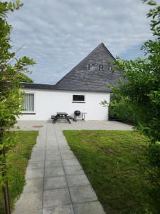 a white building with a black roof at Ferielejlighed ved Vilsted Sø in Løgstør