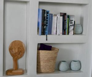 a white book shelf with books and vases at VILLA AMBROSIA in Khálara