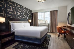 a hotel room with a bed and a desk at Hotel Alex Johnson Rapid City, Curio Collection by Hilton in Rapid City +164 photos
