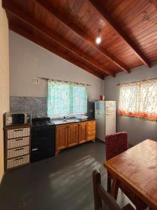 a kitchen with a stove and a refrigerator and a table at Romedeptos II in Merlo