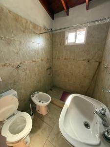 a bathroom with a toilet and a sink and a tub at Romedeptos II in Merlo