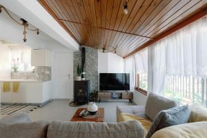 a living room with a couch and a tv at Skyloft - Rooftop Jacuzzi & Sea View - Central Kos in Kos